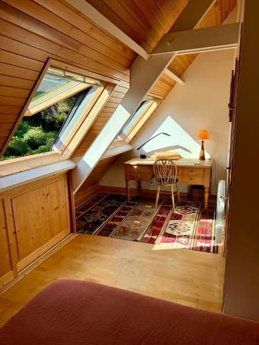 Cette chambre mansardée comprend un bureau et 2 fenêtres. dans l'établissement Chambre Les Oliviers, à Fouesnant