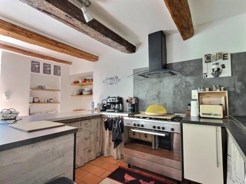 une cuisine avec une cuisinière et un comptoir dans l'établissement Le Moulin de Bouzigue, à Valleraugue