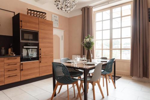 a dining room with a table and chairs at Au Formi'Dole, terrasse avec vue canal in Dole