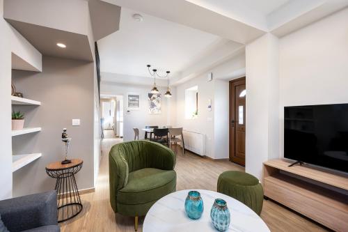 a living room with a table and chairs and a television at Latour Inspired by Elegance in (( Kermetés ))