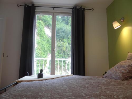 Un dormitorio con una cama y una ventana grande. en Appartement lumineux au centre de dieppe, calme et confortable, en Dieppe