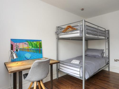 a room with a desk and a bunk bed at Harbourside Apartment in Pwllheli