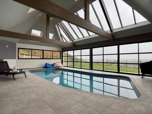 - une grande piscine dans une maison dotée de fenêtres dans l'établissement Amfreville la Mivoie - Villa Belle vue - Piscine, à Amfreville-la-Mi-Voie