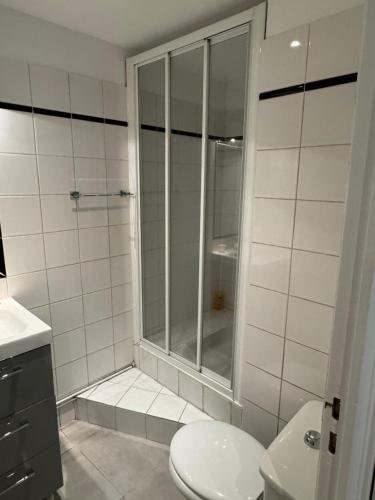 une salle de bain blanche avec douche et toilettes dans l'établissement Appartement entier aux Abbesses - Montmartre - Flat in Montmartre, à Paris