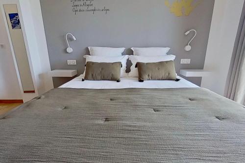 a bedroom with a large bed with two pillows at ARGIALE - ARGHJALE in Figari