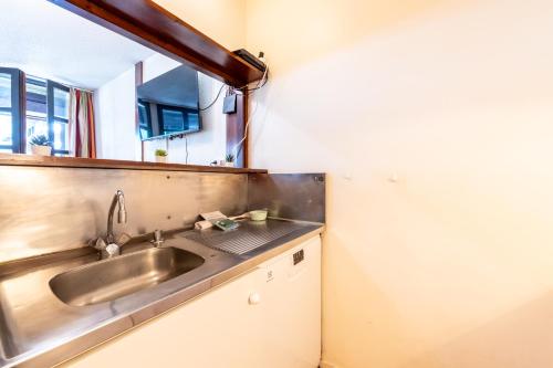 - une cuisine avec un évier et un miroir dans l'établissement Chamonix Sud - Jonquilles 328 - Happy Rentals, à Chamonix-Mont-Blanc