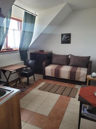 a living room with a bed and a table at Tótvár lovarda szálláshely in Kővágótőttős