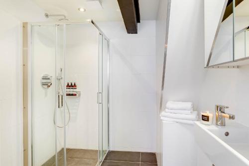 a shower with a glass door in a bathroom at Haarlem Hotel Suites in Haarlem
