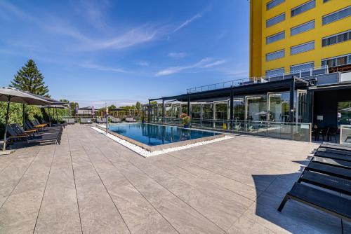 a building with a swimming pool next to a building at Hotel Aura Design & Garden Pool in Prague