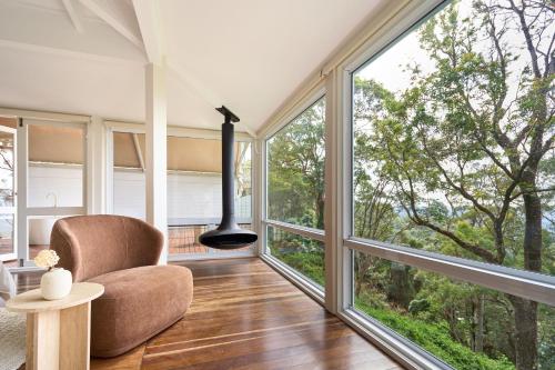 a living room with large windows and a chair at Karma Suites - Heart of Montville in Montville