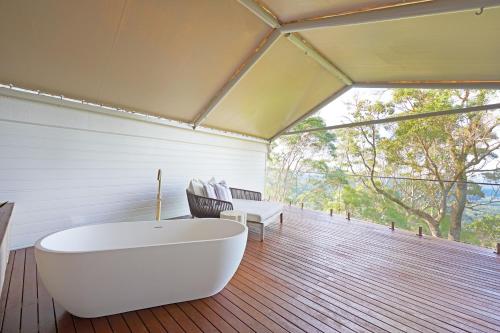 a bathroom with a tub on a wooden floor at Karma Suites - Heart of Montville in Montville