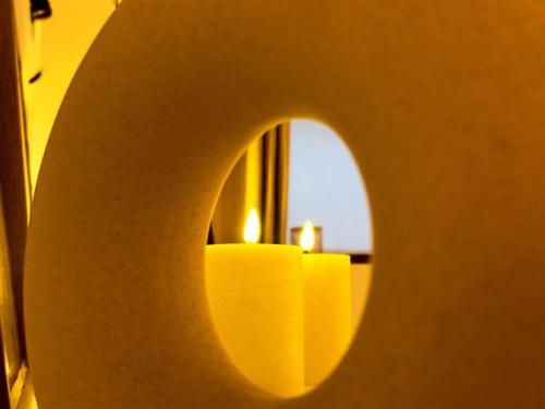 a yellow candle in front of a mirror at Casa Love in Déville-lès-Rouen