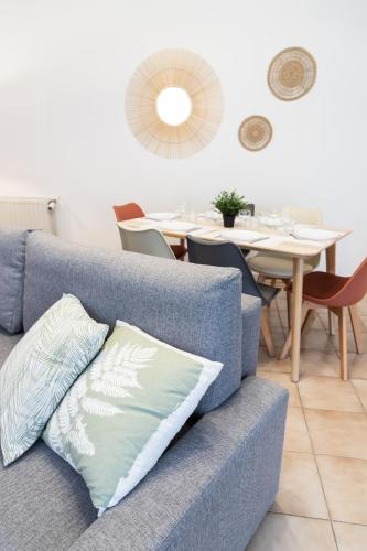 un canapé bleu dans un salon avec une table dans l'établissement Charmant duplex T3 centre historique Muret, à Muret