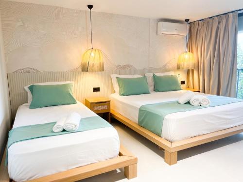 a bedroom with two beds with green and white pillows at Siar Rooms in Durrës