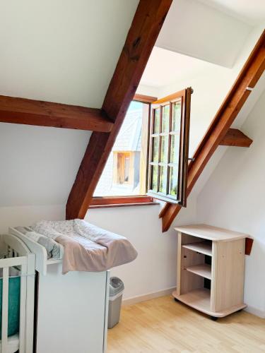 une chambre avec un lit et une fenêtre dans l'établissement Le Malis - Charming half-timbered family house with large garden, à Saint-Jouin
