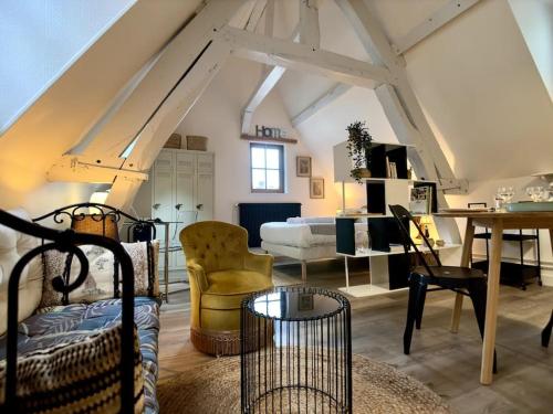 Cette chambre mansardée comprend un lit, une table et des chaises. dans l'établissement Rouen Hyper centre - L'Antiquaire, à Rouen
