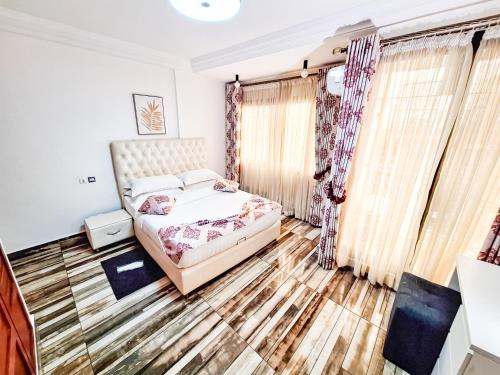 a bedroom with a bed and curtains at BELMANN BONAPRISO in Douala