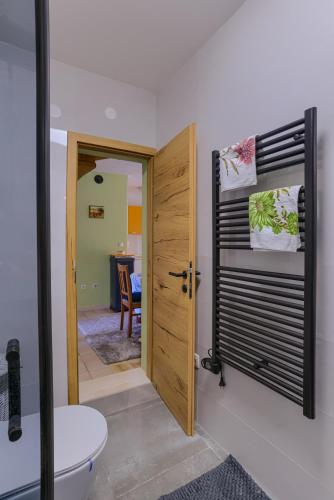 a bathroom with a toilet and a wooden door at Loft Panorama in Korčula
