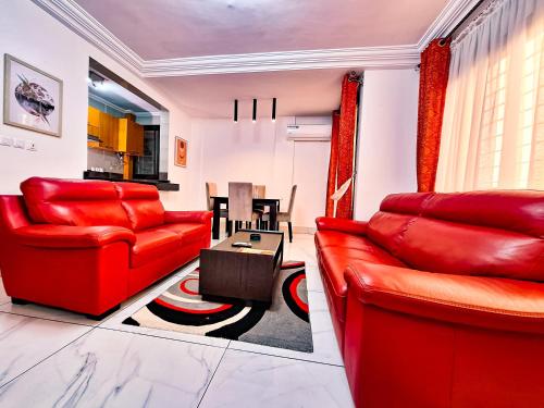 a living room with red furniture and a table at BELMANN BONAPRISO in Douala