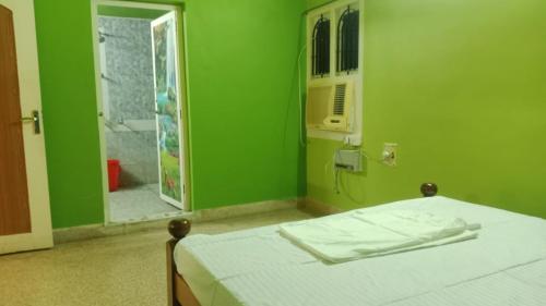 a green room with a bed and a shower at Square & Dormitory Stays in Tirunelveli