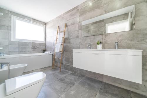 ein Badezimmer mit Waschbecken, Badewanne und Toilette in der Unterkunft Villa Alva in Aroeira