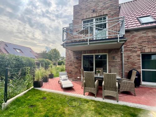 a patio with chairs and a balcony on a house at Sieltied in Greetsiel