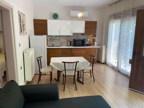 a kitchen and dining room with a table and chairs at Ενοικιαζόμενα Έλενα in Therma