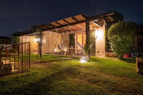 a backyard at night with a pergola at Olimagio Farm Stay with animals and 25m pool, beach at cycling distance in Pietrasanta
