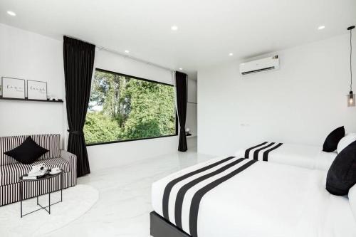 ein Schlafzimmer mit einem Bett und einem großen Fenster in der Unterkunft Sea'cret Stay Villa Pattaya พัทยา พูลวิลล่าพัทยา ใกล้ทะเล in Na Jomtien