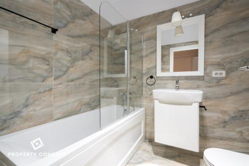 une salle de bains avec baignoire et lavabo dans l'établissement Central Residence Apartment 711 B4, à Vatra Mînăstirii Cotroceni