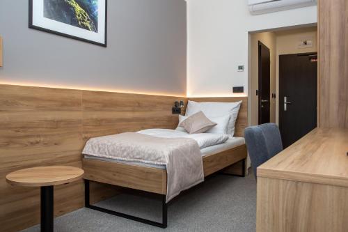 a small bedroom with a bed and a table at Hotel Slovakia in Trenčianske Teplice