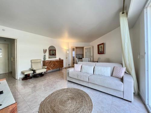 un salon avec un canapé et une chaise dans l'établissement 'Le Victoria Beach' Vue Mer Plein Centre, Spacieux, à Menton