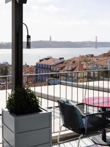 a balcony with a table and chairs and a view of the water at Bairro Alto Hotel in Lisbon