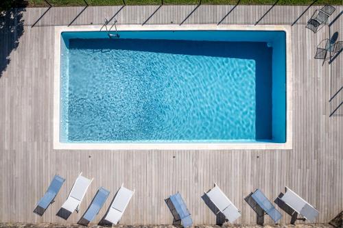 an overhead view of a swimming pool with chairs next to it at Le Prieuré Corrèze in Corrèze
