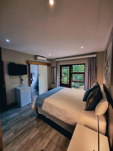 a hotel room with a large bed and a television at Cycad Place Midrand Guesthouse and B&B in Midrand
