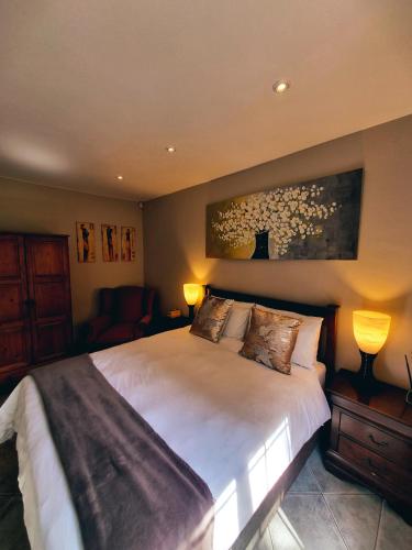 a bedroom with a large bed with two lamps at Cycad Place Midrand Guesthouse and B&B in Midrand