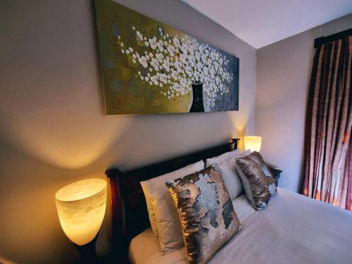 a bedroom with a bed and a painting on the wall at Cycad Place Midrand Guesthouse and B&B in Midrand