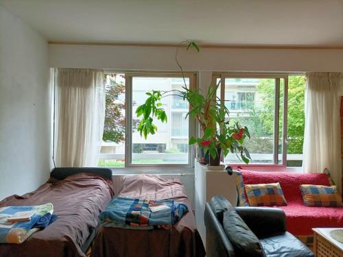 - une chambre avec un lit, un canapé et des fenêtres dans l'établissement Green Paris, à Neuilly-sur-Seine