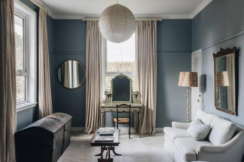 a blue living room with a couch and a table at Seymour House in Moss Vale