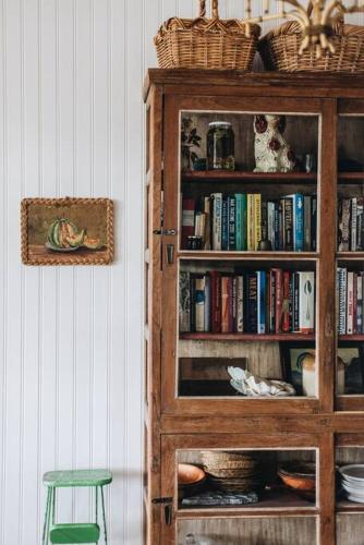 a book shelf filled with books and a green stool at Seymour House in Moss Vale