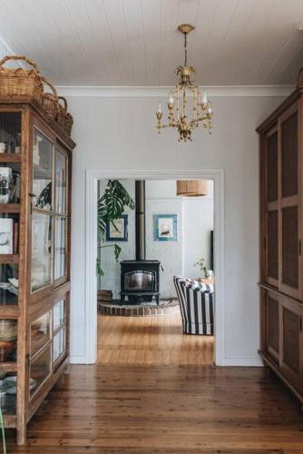 a living room with a chandelier and a fireplace at Seymour House in Moss Vale