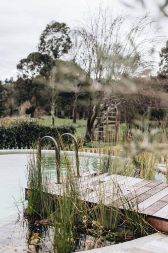 a wooden dock in the middle of a body of water at Seymour House in Moss Vale