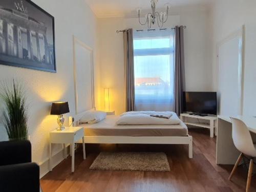 a white bedroom with a bed and a window at coLodging Mannheim - private rooms & kitchen in Mannheim
