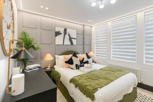 a bedroom with a large bed and a desk with a bed sidx sidx at Unwind in Style 2BR with Cozy Backyard for Groups in London