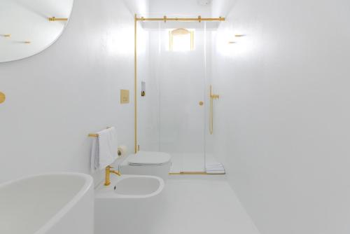 a white bathroom with a shower and a toilet at Dome Hotel in Marsala
