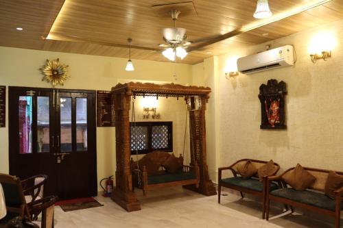 a living room with two chairs and a mirror at Satshree Kothi in Varanasi