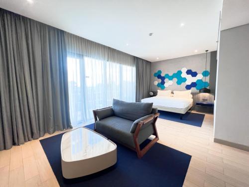 a living room with a couch and a bed at ibis Styles Batam Nagoya in Nagoya