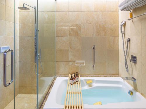 a bathroom with a tub and a shower at Kumamoto Hotel Castle in Kumamoto