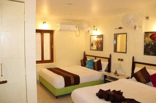 a hotel room with two beds and a window at Satshree Kothi in Varanasi