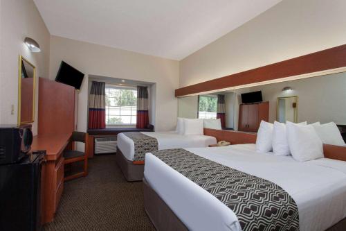 a hotel room with two beds and a television at Microtel Inn and Suites by Wyndham - Lady Lake/ The Villages in The Villages